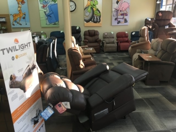 A photo of the lift chair display area at Access Medical Equipment Co. Dozens of lift chairs are displayed on the floor with a Golden Twilight lift chair product banner in the foreground.